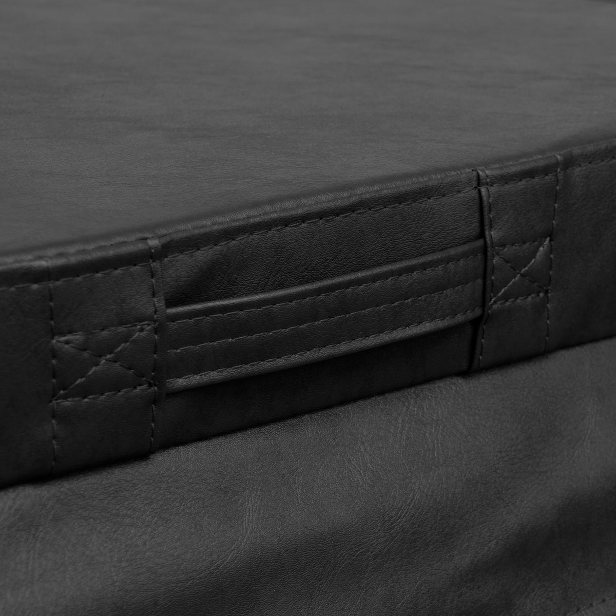 Capa de almofada preta em material sintético, com textura suave e costuras detalhadas, apresentando alças laterais para fácil manuseio