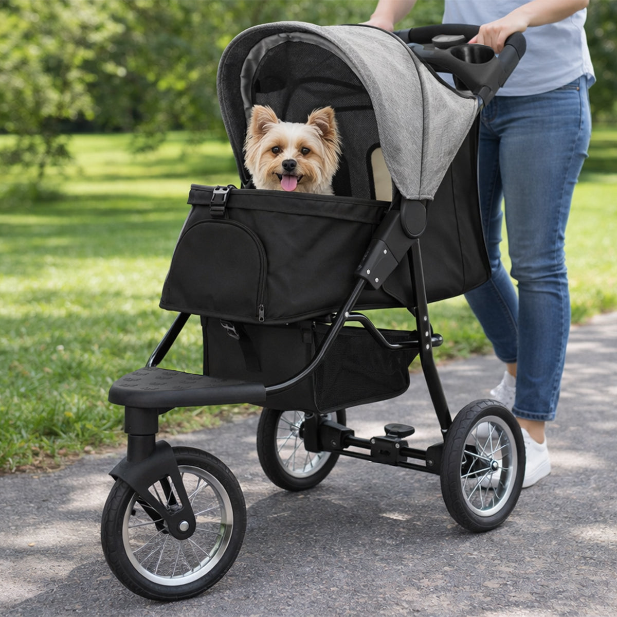 Carrinho de pet cinza com assento acolchoado, rodas grandes e espaço para armazenamento, ideal para passeios ao ar livre com animais de estimação