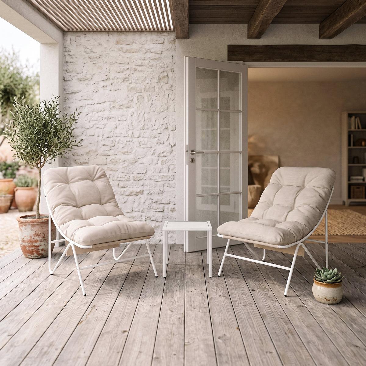 Conjunto de jardim de 3 peças em creme, com cadeiras acolchoadas e mesa branca, em ambiente externo com piso de madeira e plantas decorativas