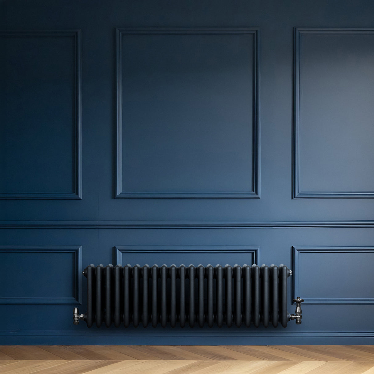 Radiador tradicional de 4 colunas em cinza antracite, instalado em parede azul escura, com textura lisa e acabamento elegante