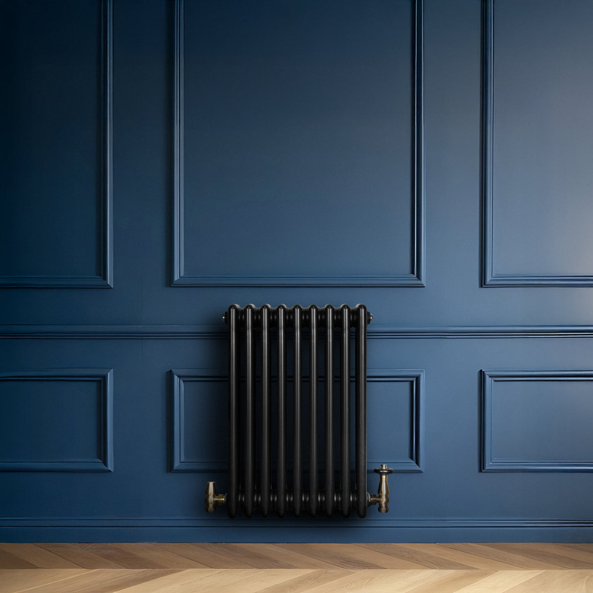 Radiador tradicional de 4 colunas, 600 x 425 mm, na cor preta, com acabamento liso e detalhes em metal dourado, instalado em parede azul