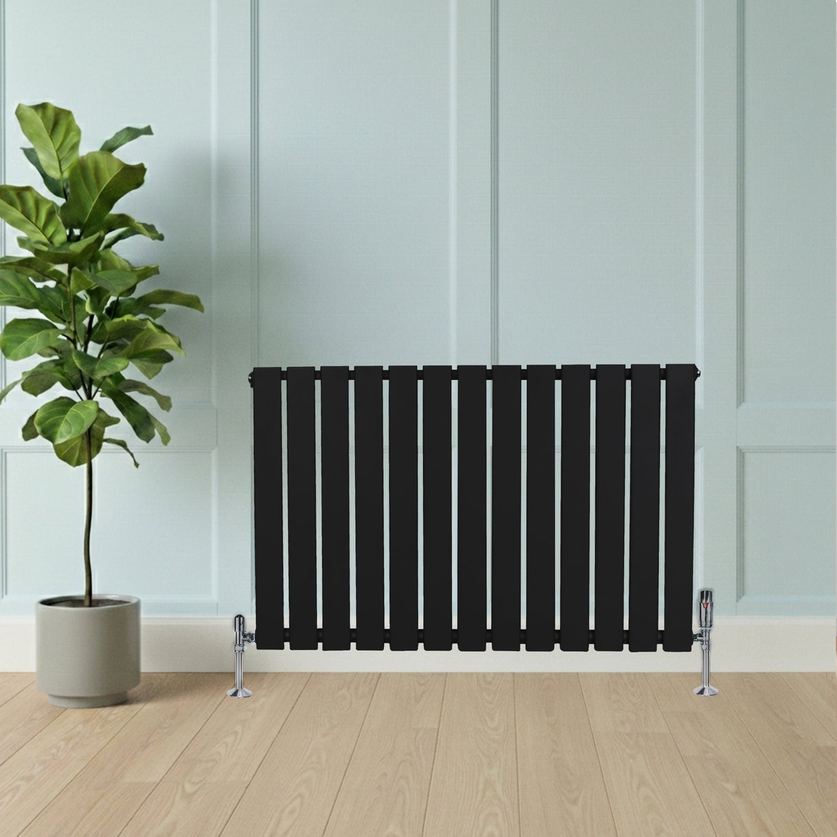 Radiador de coluna única preto, com design moderno e listras verticais, instalado em ambiente minimalista com planta ao lado
