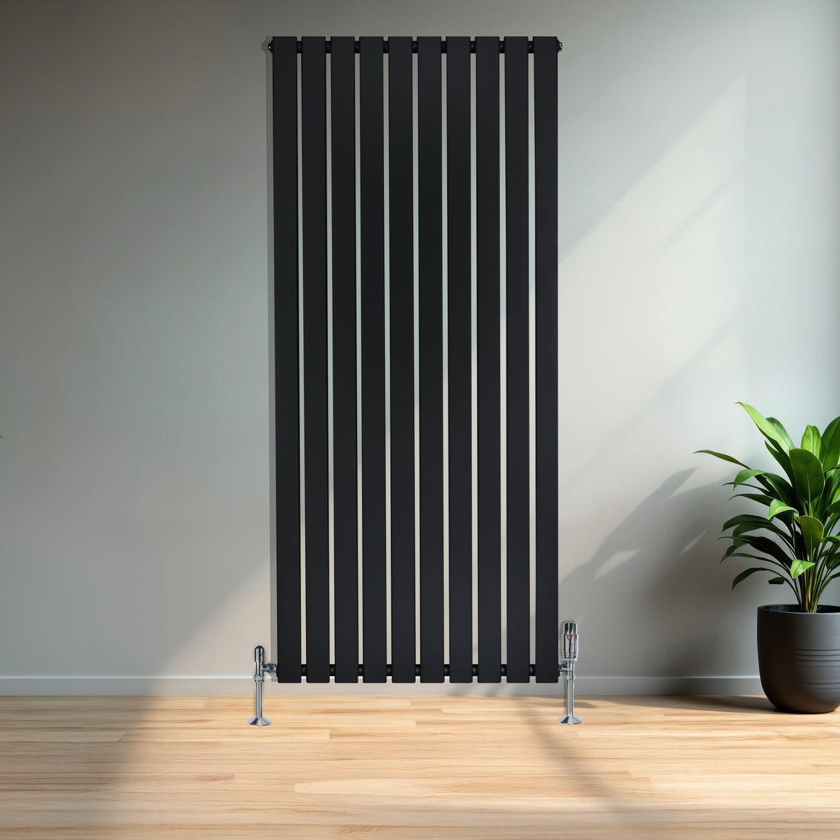 Radiador de coluna única preto, com design vertical e listras finas, instalado em parede clara, ao lado de planta em vaso preto