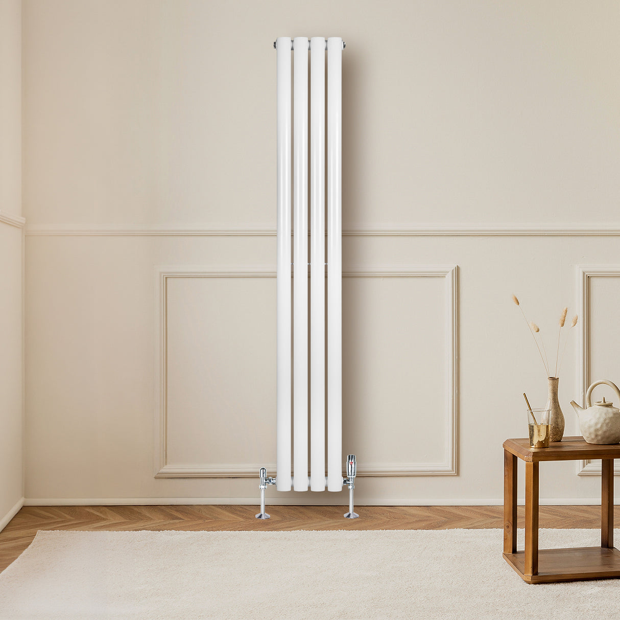 Radiador de coluna simples oval branco, com quatro tubos verticais, instalado em parede clara, ao lado de mesa de madeira e tapete claro