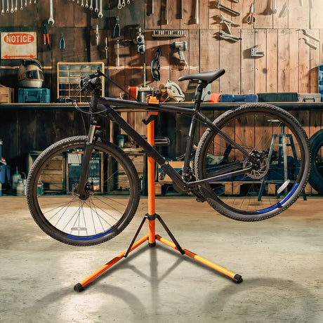 Suporte de reparação para bicicletas em laranja e preto, com uma bicicleta montada, em um ambiente de oficina bem iluminado