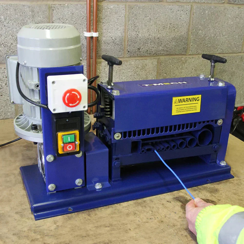 Máquina azul de desencapar fios com motor cinza, botões coloridos e cabo azul sendo inserido, ideal para processamento de cabos