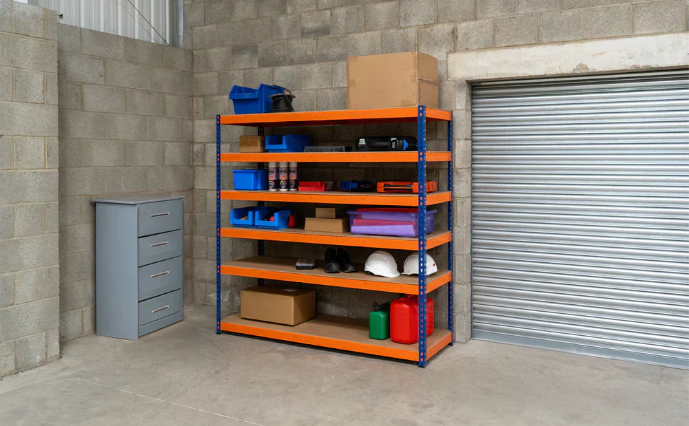 Estante de garagem com prateleiras laranja e azul, organizada com caixas, ferramentas, capacetes e produtos de limpeza, em ambiente de concreto