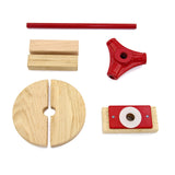 Conjunto de peças de madeira em tons claros e vermelho, incluindo um disco, um suporte, uma barra e um conector em formato triangular
