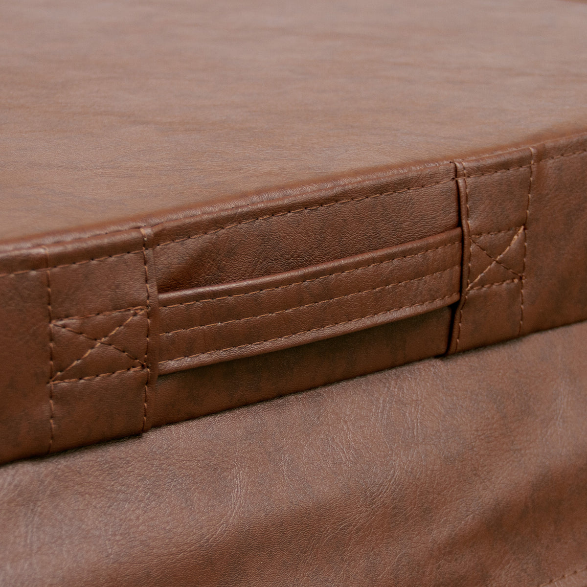 Colchão marrom em material sintético, com textura suave e costuras reforçadas, destacando alças laterais para fácil manuseio