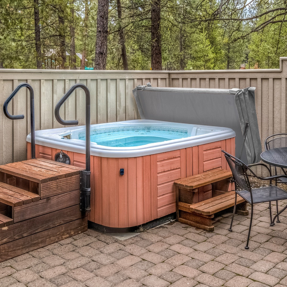 Cobertura cinza para jacuzzi 2,1m x 2,1m, com textura suave, se encaixa perfeitamente sobre a jacuzzi em ambiente externo com piso de pedras