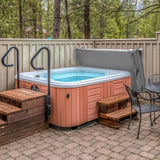 Cobertura cinza para jacuzzi 2,1m x 2,1m, com textura suave, se encaixa perfeitamente sobre a jacuzzi em ambiente externo com piso de pedras