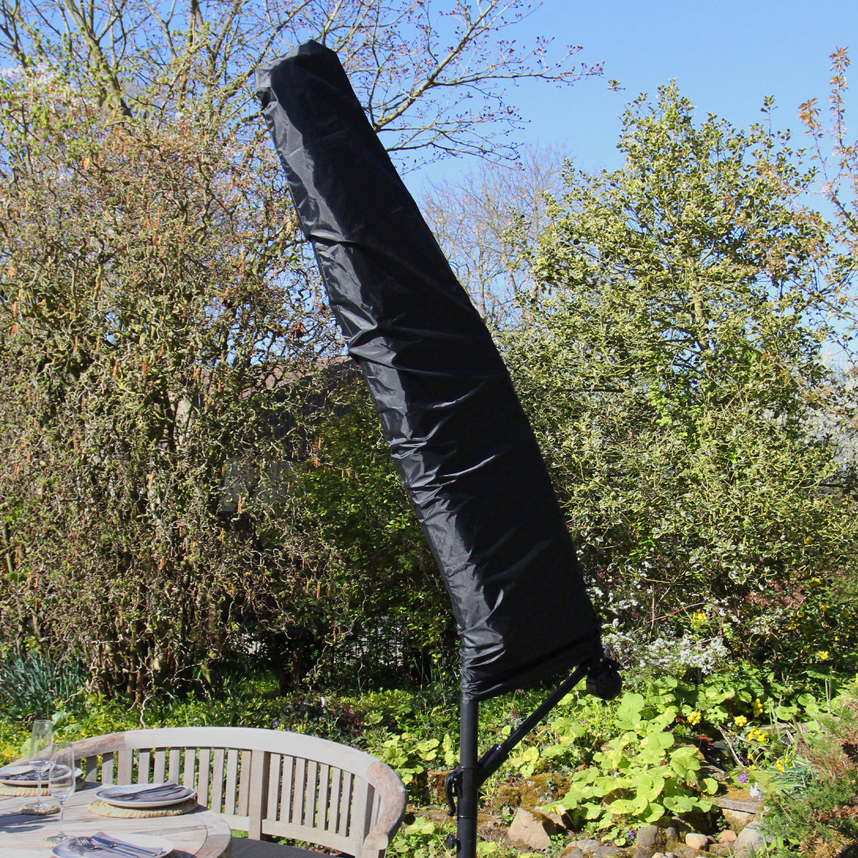 Conjunto de sofá em antracite com guarda-sol preto, ideal para áreas externas, com design elegante e moderno em um ambiente natural