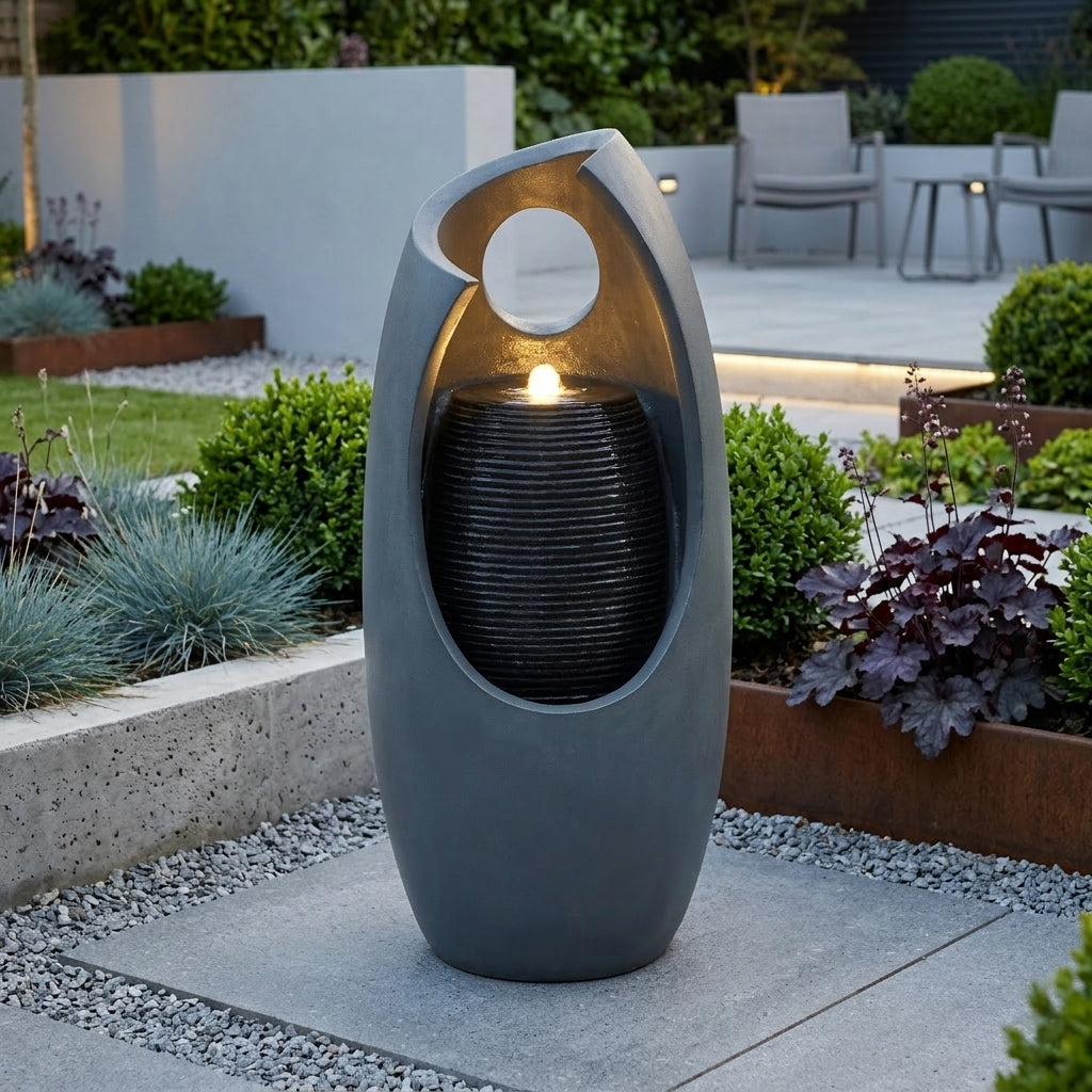 Fonte de água elétrica "Radiant Falls" em formato moderno, cinza, com luz suave e texturas de pedra, ideal para jardins elegantes
