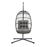 Cadeira suspensa tipo ovo em rattan preto, com estrutura metálica e almofada cinza acolchoada, ideal para relaxar e decorar ambientes