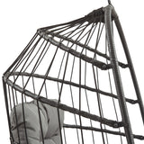 Cadeira suspensa tipo ovo em rattan preto, com estrutura de fios entrelaçados e almofada cinza, ideal para relaxar e decorar ambientes