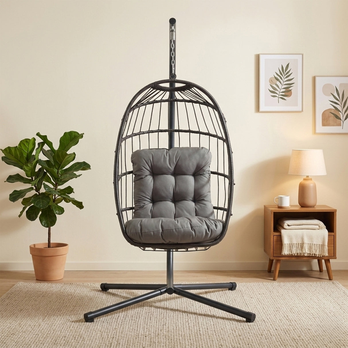 Cadeira suspensa tipo ovo em rattan preto, com almofadas cinzas, estrutura metálica e design moderno, ideal para decoração aconchegante
