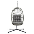 Cadeira suspensa tipo ovo em rattan cinzento, com estrutura metálica e almofada acolchoada, ideal para relaxar em ambientes internos ou externos