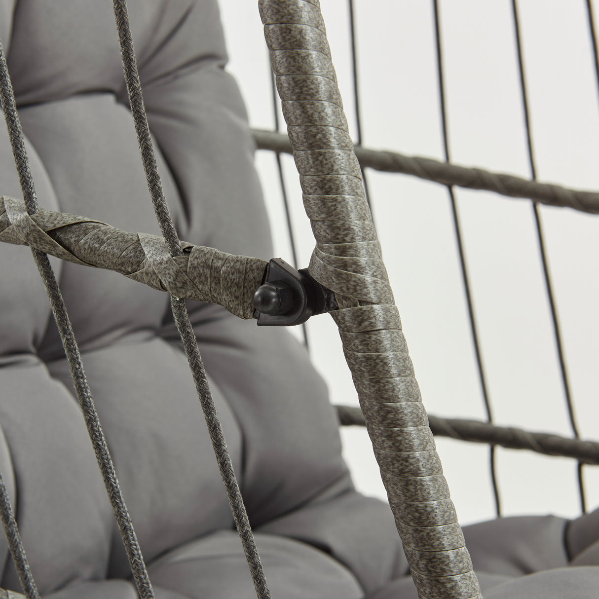 Cadeira suspensa tipo ovo em rattan cinzento, com almofadas acolchoadas e estrutura de corda trançada, ideal para relaxar