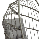Cadeira suspensa tipo ovo em rattan cinzento, com estrutura trançada e almofadas cinzas, ideal para relaxar em ambientes internos ou externos