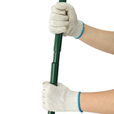 Nivelador de relva verde de 100 cm sendo segurado por mãos com luvas, destacando o material resistente e a textura do cabo