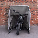 Cabine de proteção para motocicleta em tom cinza, com estrutura metálica, abrigando uma moto de design moderno contra intempéries