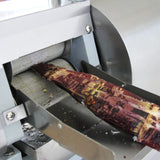 Máquina de suco de cana de aço inoxidável com cana sendo processada, mostrando detalhes do metal e textura da cana fresca