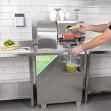 Máquina de suco de cana em aço inox, com alavanca e recipiente transparente coletando suco fresco, em ambiente moderno e limpo