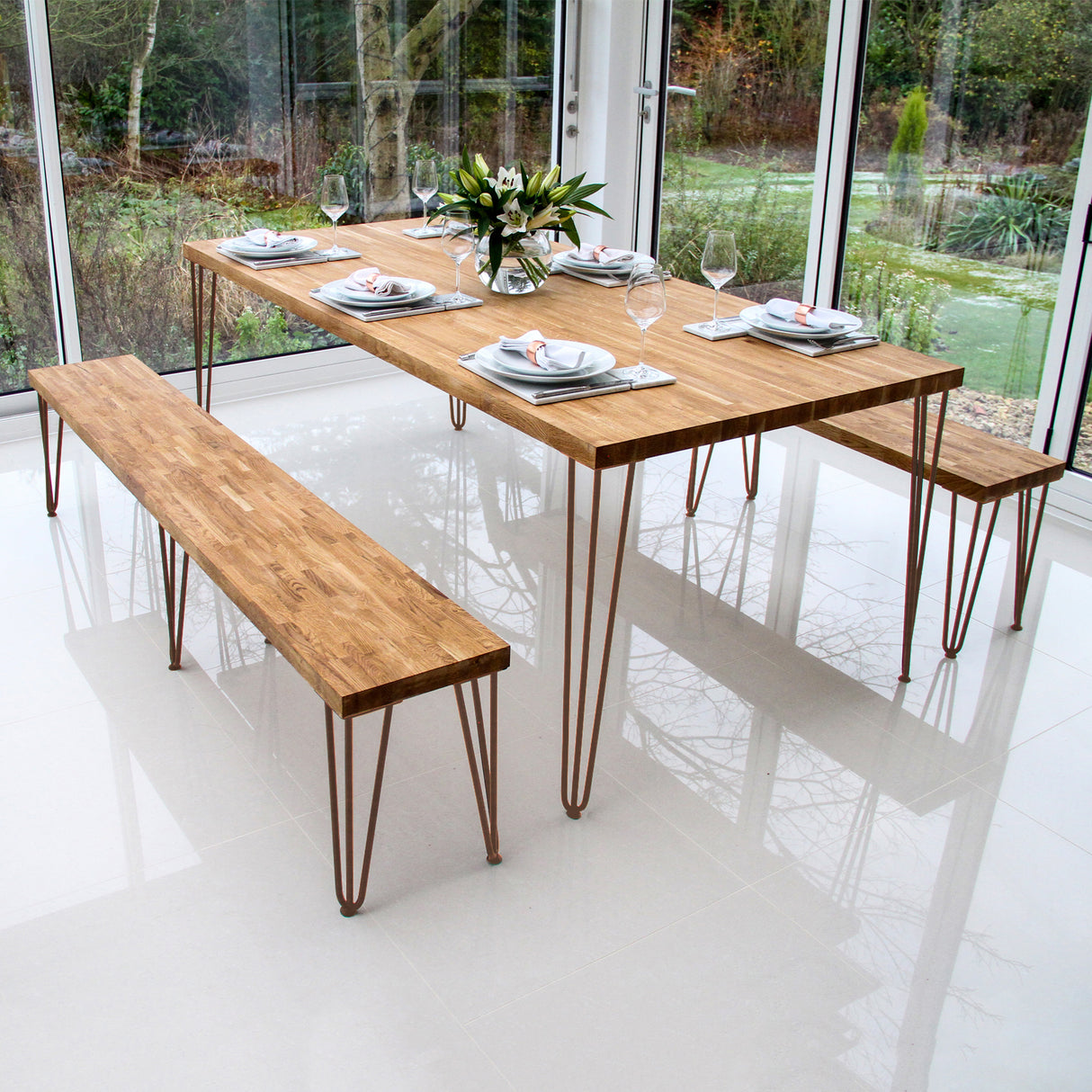Pernas de garfo para mesa em metal, altura de 30,5 cm, com acabamento em bronze e design moderno, suportando uma mesa de madeira clara