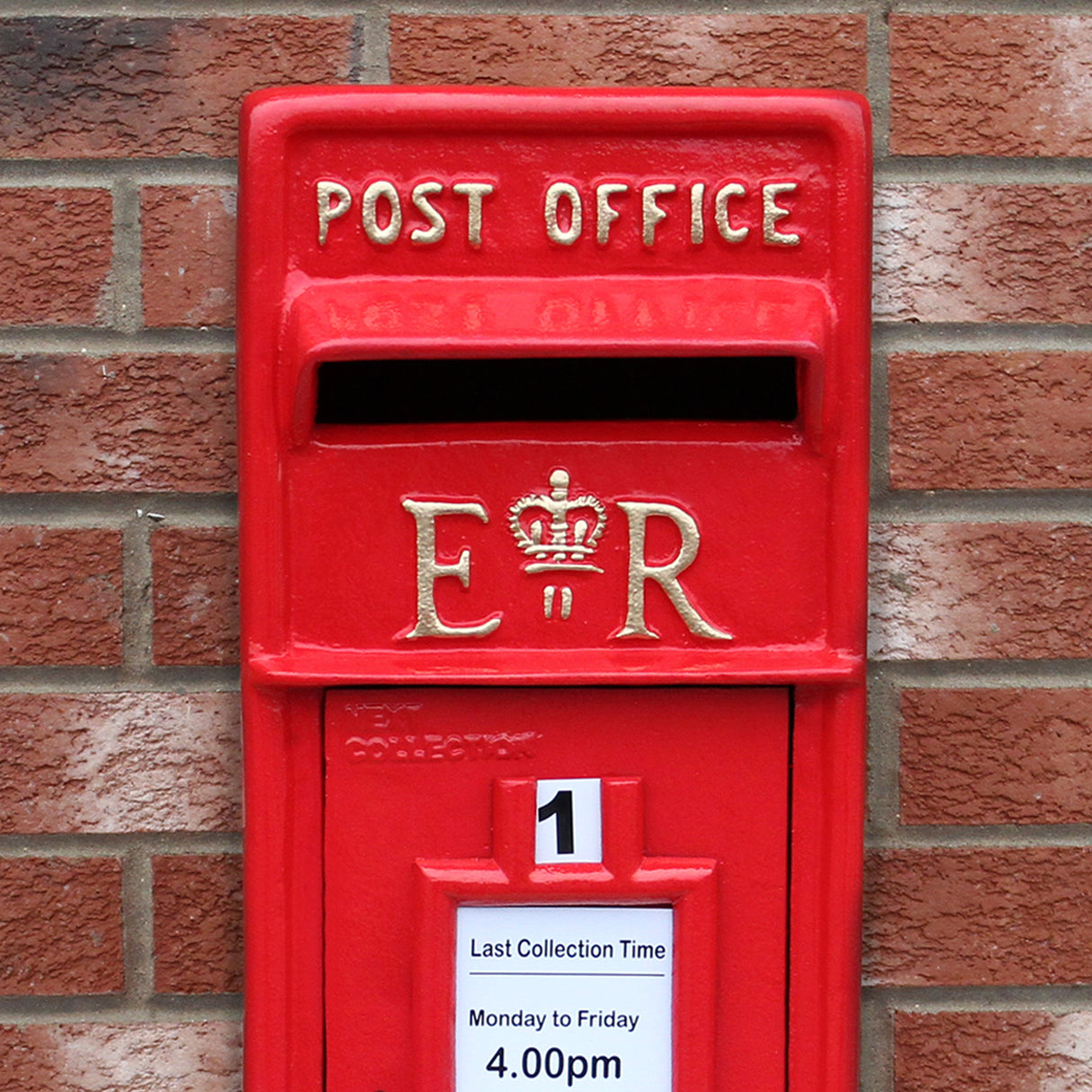 Caixa de correio Royal Mail vermelha com detalhes em dourado, destacando o símbolo da coroa e um aviso de horário de coleta