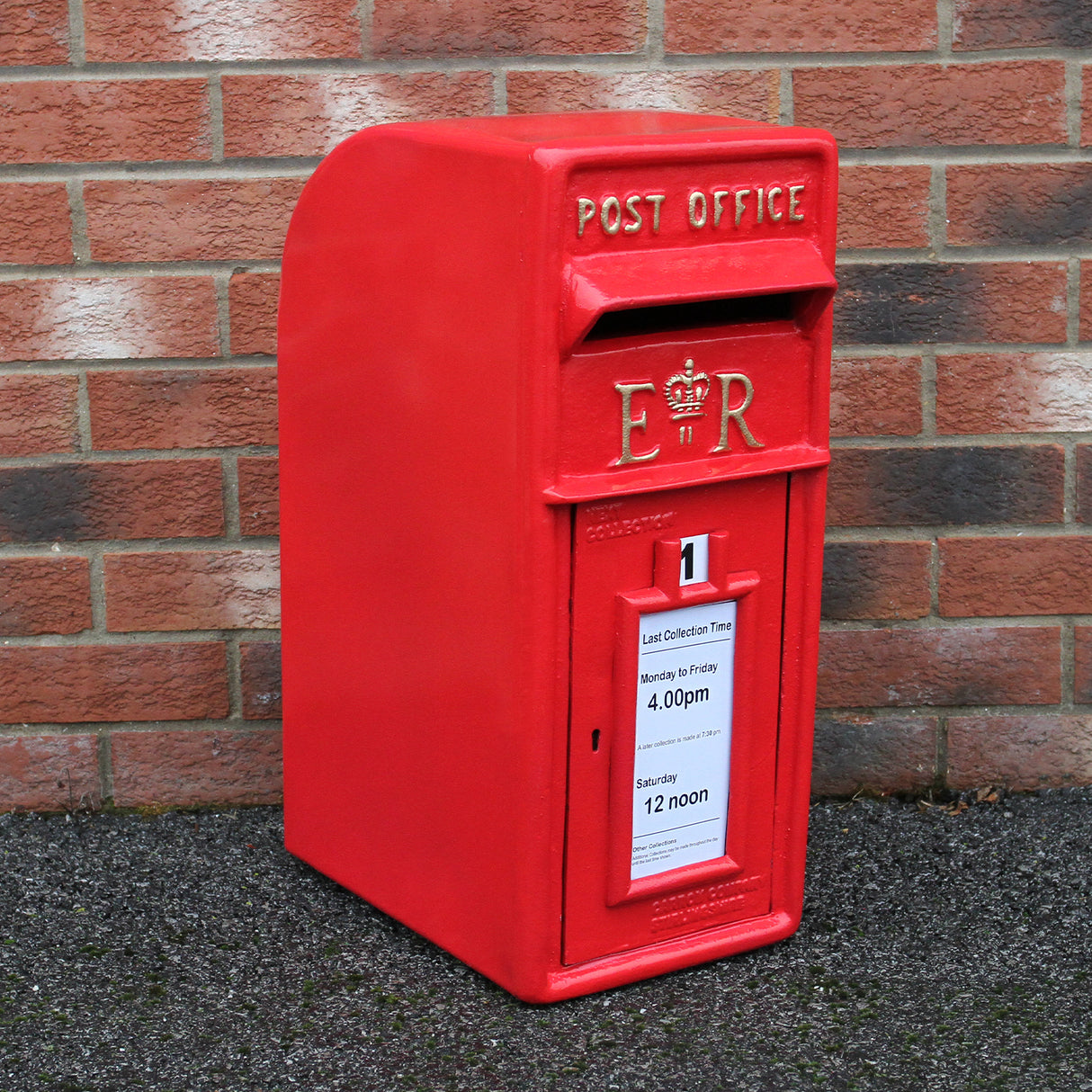 Caixa de correio Royal Mail vermelha com suporte, detalhes em relevo e etiqueta de horário de coleta visível na frente