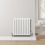 Radiador de coluna oval branco com válvulas, instalado na parede, com acabamento liso e moderno, ideal para aquecimento de ambientes