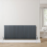 Radiador de coluna oval cinza antracite, com válvulas, instalado em parede clara, destacando seu design moderno e elegante
