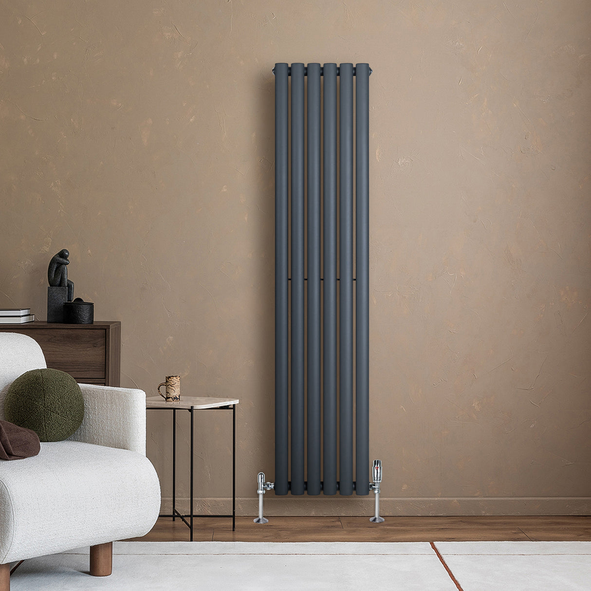 Radiador de coluna oval cinza antracite, com design moderno e acabamento liso, instalado em parede de tom neutro, ao lado de móveis elegantes