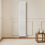 Radiador de coluna simples oval branco, com válvulas, instalado em parede clara, destacando seu design elegante e moderno