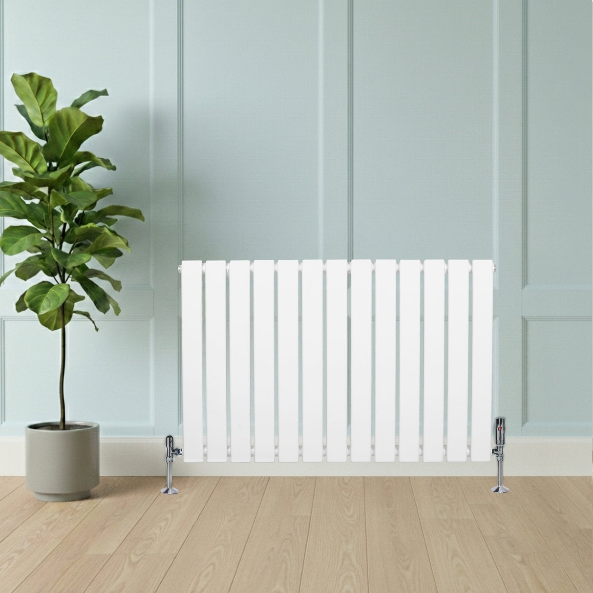 Radiador plano de coluna simples branco com válvulas, instalado em parede clara, ao lado de planta em vaso e piso de madeira clara