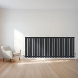Radiador plano de coluna simples cinza antracite, com design elegante e moderno, instalado em parede clara ao lado de uma cadeira minimalista