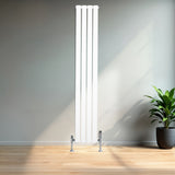 Radiador plano de coluna simples branco, 1800 mm x 280 mm, com válvulas, instalado em ambiente moderno com piso de madeira e planta decorativa