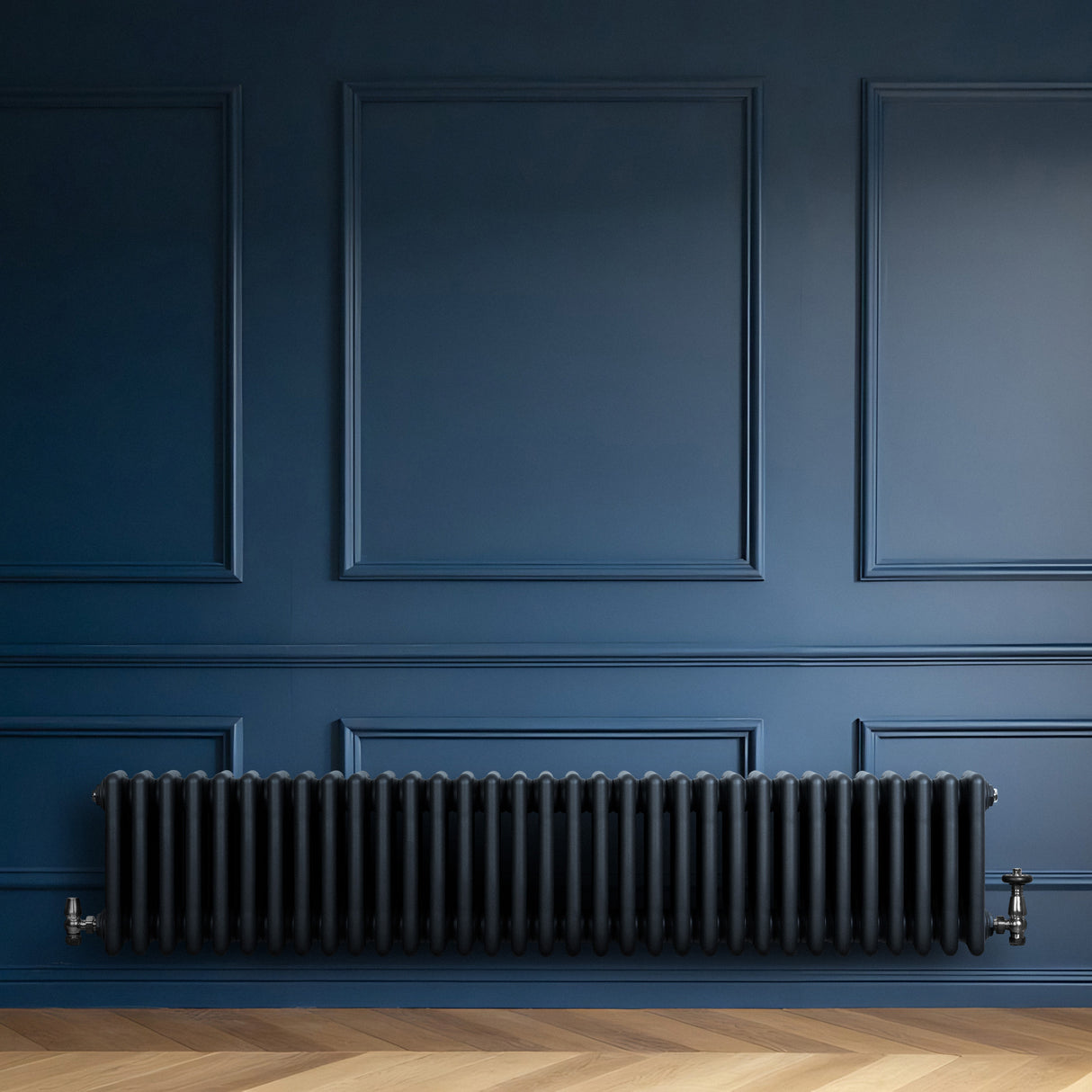 Radiador tradicional de 4 colunas, cinza antracite, com válvulas, instalado em parede azul, destacando seu design elegante e moderno