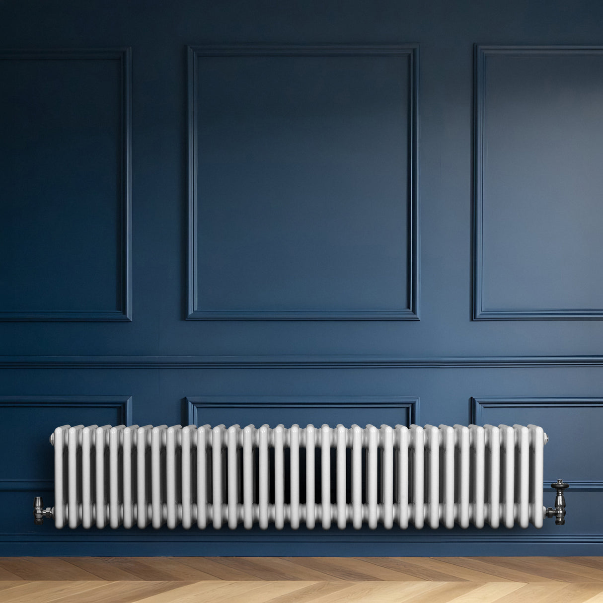 Radiador tradicional de 4 colunas em branco, instalado em parede azul, com válvulas visíveis e textura suave, ideal para aquecimento