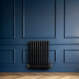 Radiador tradicional preto de 4 colunas, com válvulas, instalado em parede azul, destacando seu design elegante e moderno