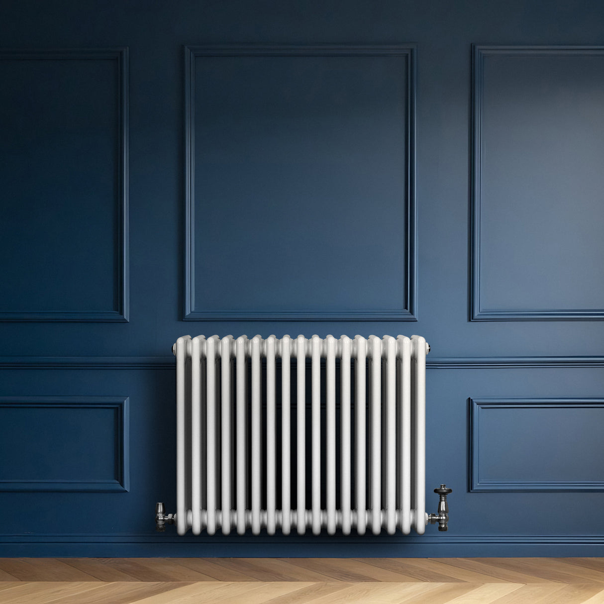 Radiador tradicional de 4 colunas em branco, instalado em parede azul, com válvulas visíveis e textura lisa, ideal para aquecimento