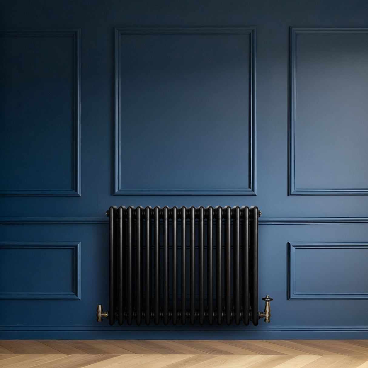 Radiador tradicional de 4 colunas, acabamento preto, instalado em parede azul, com válvulas de metal dourado e design elegante