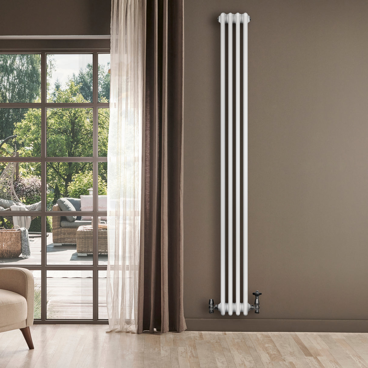 Radiador tradicional de 4 colunas, branco, instalado em parede cinza, com válvulas visíveis, ao lado de uma janela iluminada