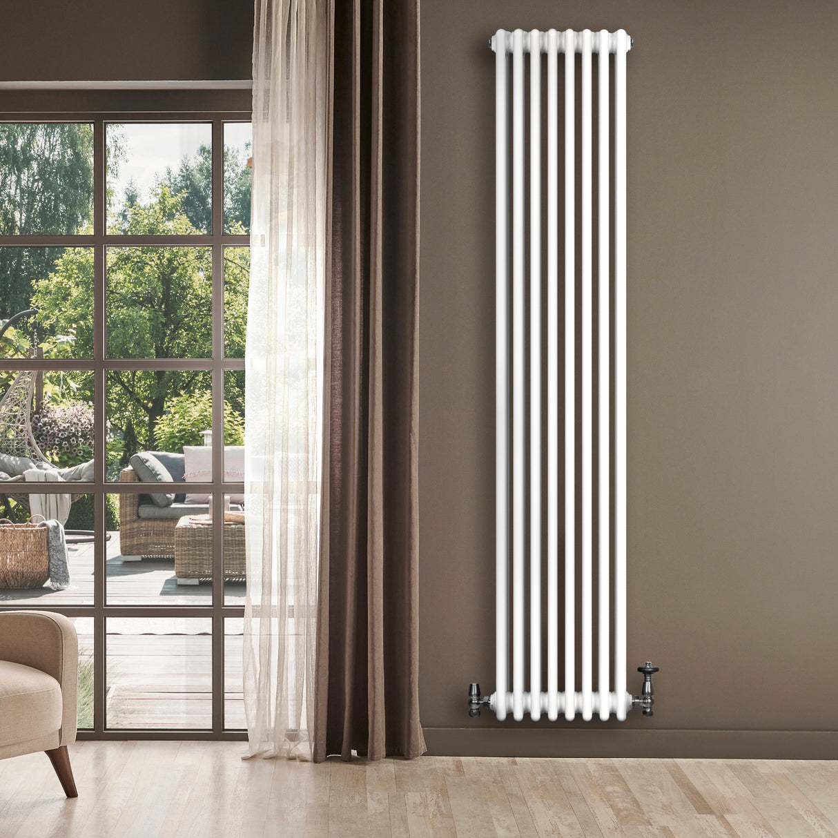 Radiador tradicional de 4 colunas, branco, com válvulas, instalado em ambiente moderno, ao lado de janela com vista externa verdejante