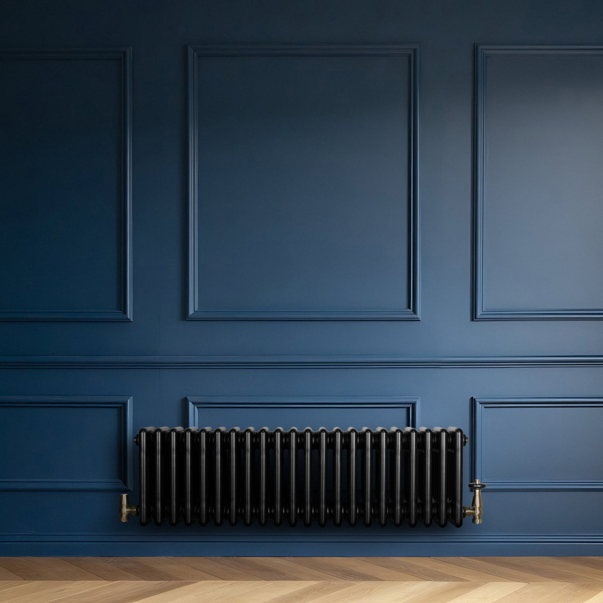 Radiador tradicional preto de 4 colunas, instalado em parede azul, com acabamento liso e detalhes em metal dourado nas conexões