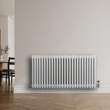 Radiador tradicional de 4 colunas em branco, instalado na parede, com acabamento liso e moderno, ideal para aquecimento de ambientes