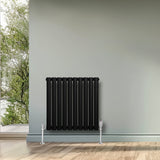 Radiador de coluna simples oval preto, com acabamento liso, instalado em parede cinza, ideal para aquecimento de ambientes modernos