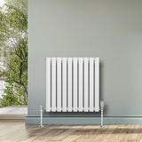 Radiador de coluna simples oval branco, 600 mm x 600 mm, com acabamento liso e moderno, instalado em parede cinza com vista para natureza