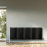 Radiador de coluna simples oval preto, 600 mm x 1620 mm, com acabamento liso e moderno, instalado em parede clara com vista para o exterior