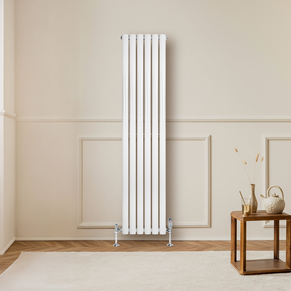 Radiador de coluna simples oval branco, com seis tubos verticais, instalado em parede clara, ao lado de mesa de madeira decorativa